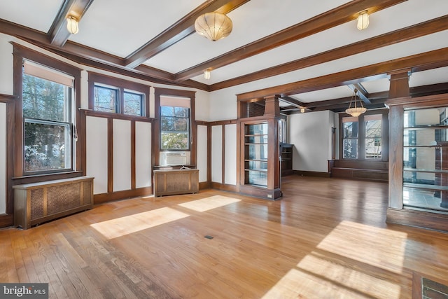 interior space with beamed ceiling, hardwood / wood-style flooring, radiator, and cooling unit