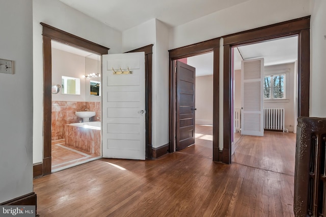 interior space with radiator heating unit and dark hardwood / wood-style flooring