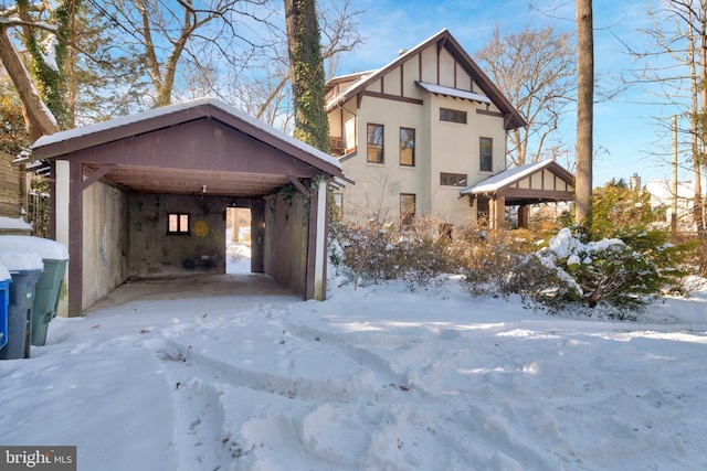 view of snow covered exterior with a carport