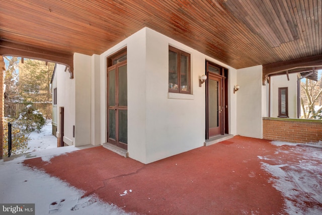 snow covered property entrance featuring a porch