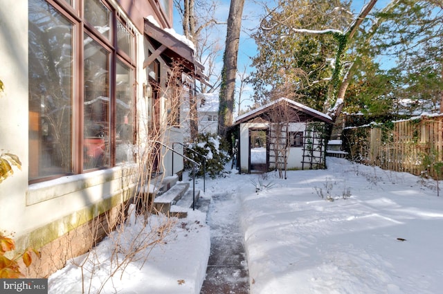 yard layered in snow with an outdoor structure