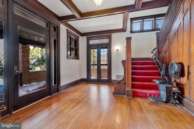 entrance foyer with beamed ceiling, coffered ceiling, french doors, and light wood-type flooring