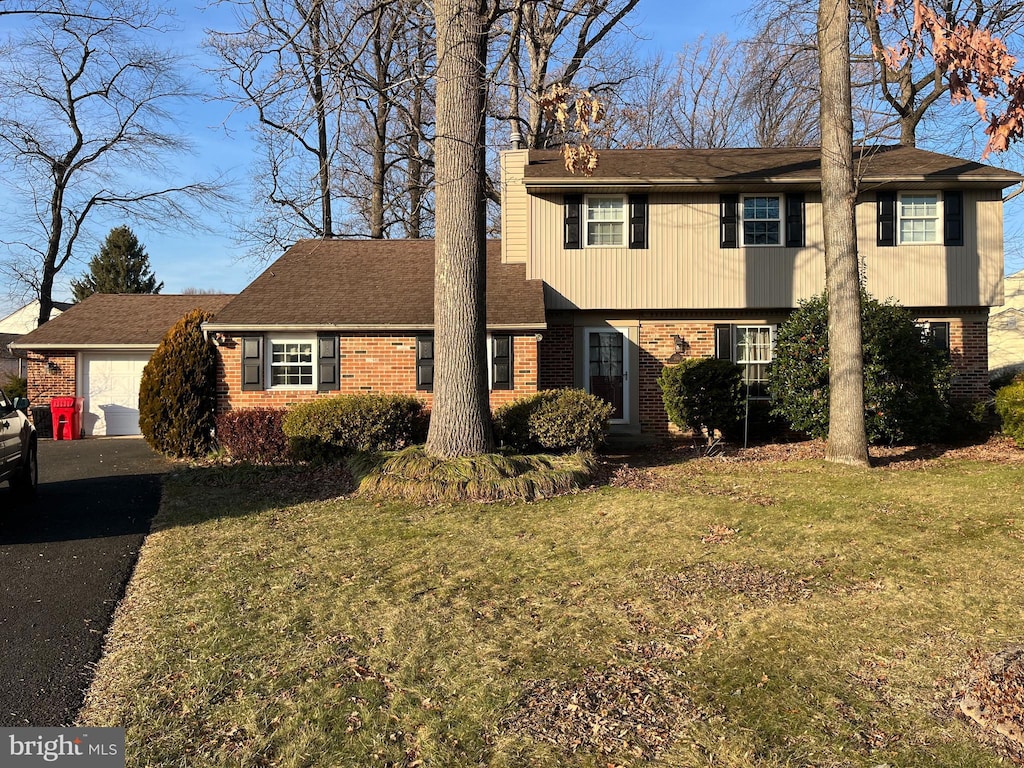 view of front of property featuring a front lawn and a garage