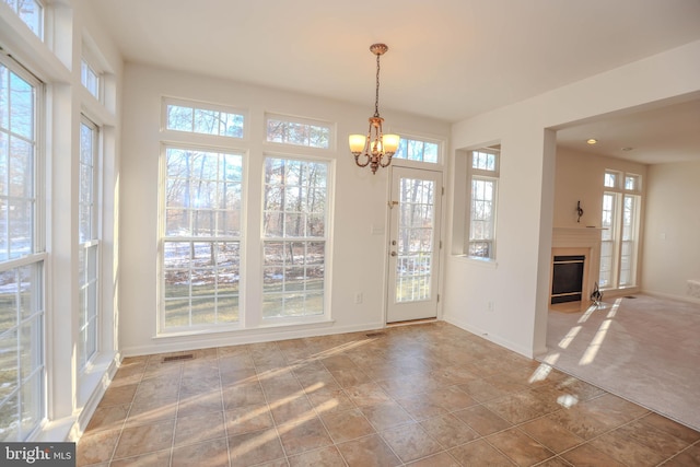 doorway to outside featuring an inviting chandelier