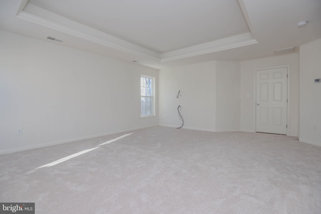 carpeted empty room with a tray ceiling