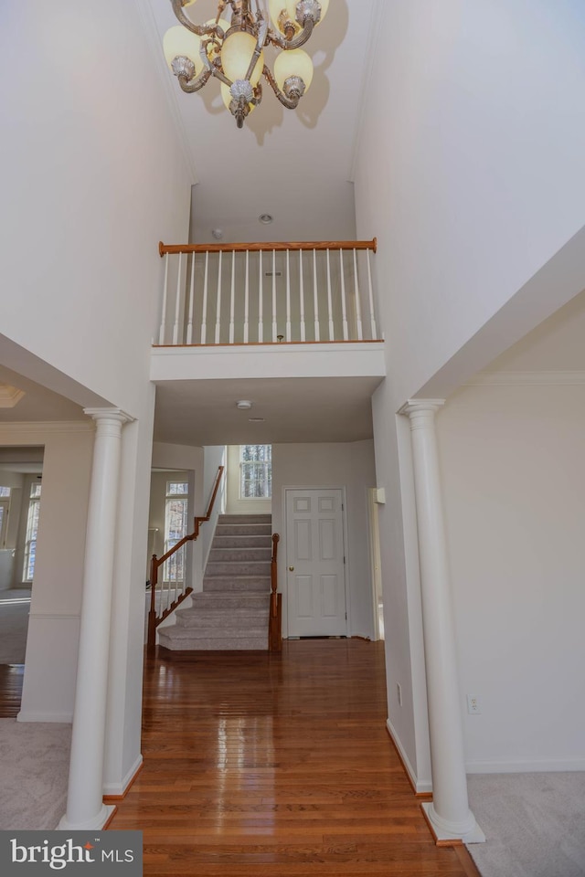 entryway with a wealth of natural light, an inviting chandelier, and a towering ceiling