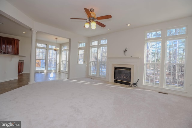 unfurnished living room featuring ceiling fan with notable chandelier and carpet floors