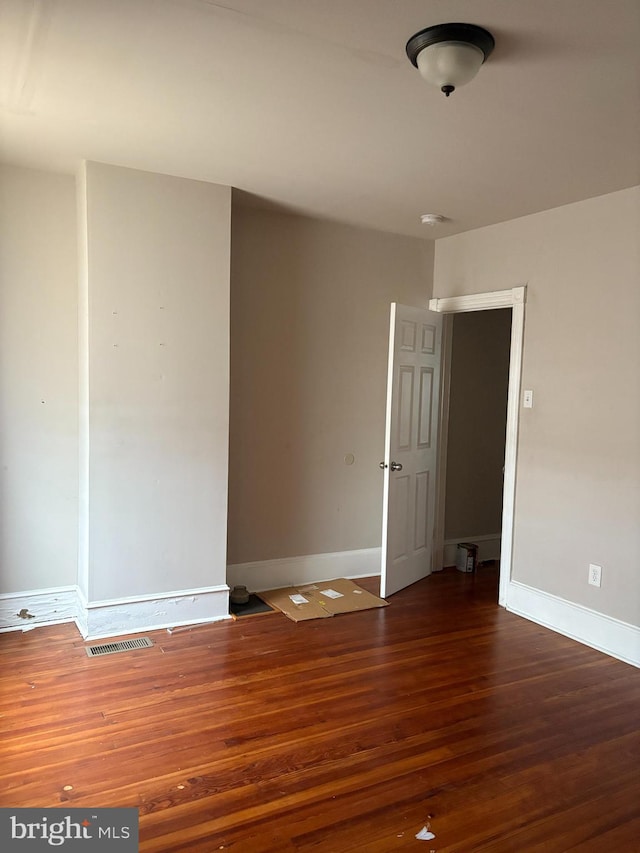 empty room featuring dark hardwood / wood-style flooring