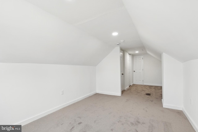 additional living space with light carpet and vaulted ceiling