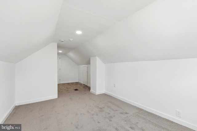 additional living space with light carpet and lofted ceiling