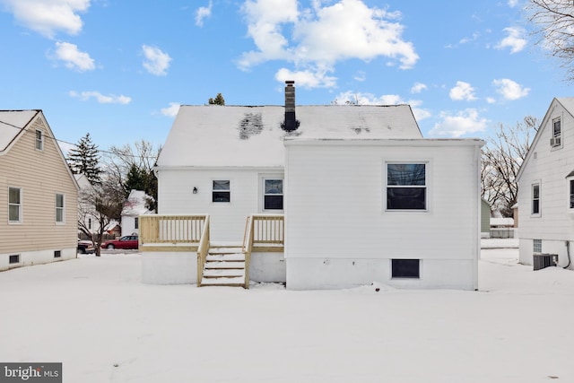 snow covered rear of property with cooling unit