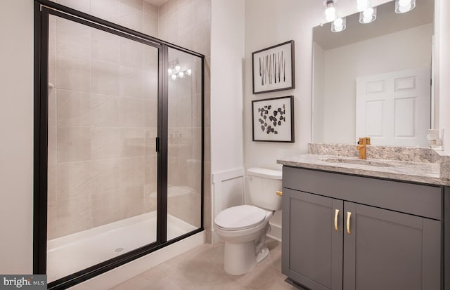 bathroom with tile patterned floors, vanity, toilet, and an enclosed shower