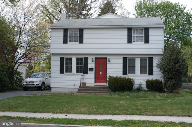 colonial-style house featuring a front lawn