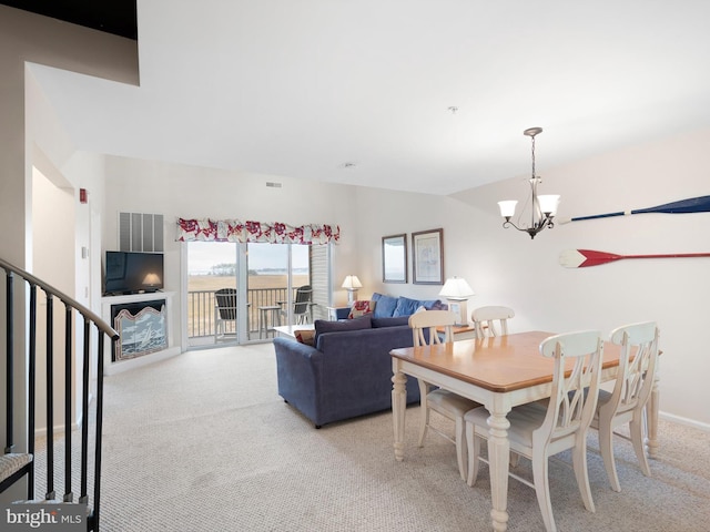 dining area with a chandelier and light colored carpet