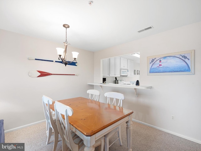 dining area with light colored carpet and a chandelier