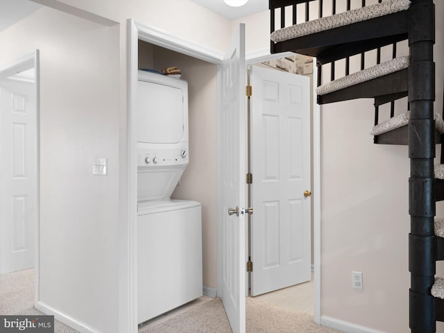 laundry room featuring light colored carpet and stacked washer / drying machine