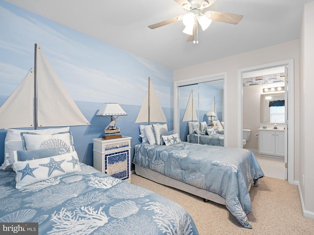 carpeted bedroom with ceiling fan, ensuite bath, and a closet