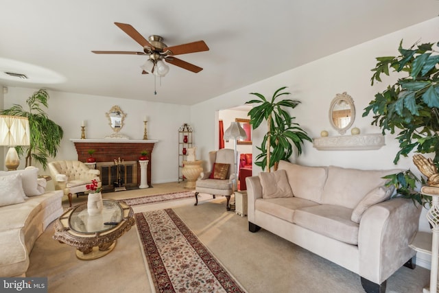 living room with ceiling fan and a fireplace