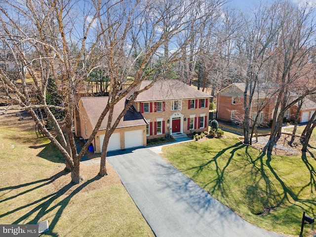 view of front of house with aphalt driveway, a front lawn, and an attached garage