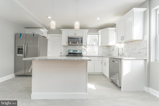 kitchen featuring sink, a center island, tasteful backsplash, white cabinets, and appliances with stainless steel finishes