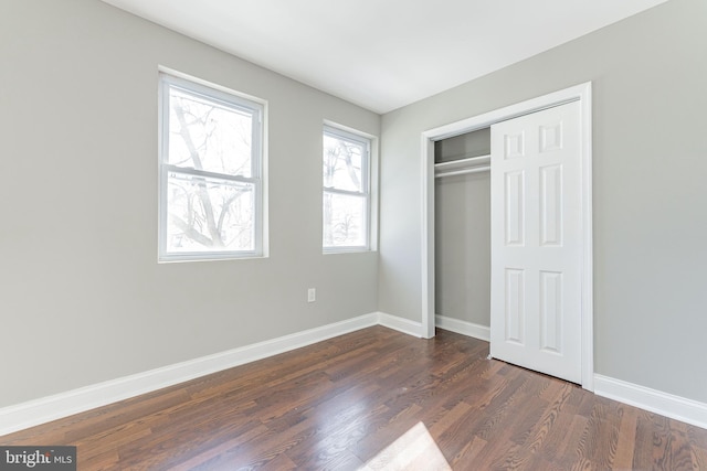 unfurnished bedroom featuring dark hardwood / wood-style flooring and a closet