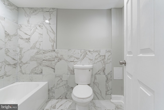 bathroom with toilet, a bath, and tile walls