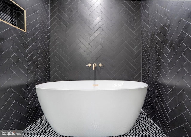 bathroom with a bathing tub and tile walls