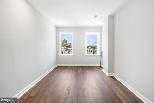 unfurnished room with dark hardwood / wood-style flooring