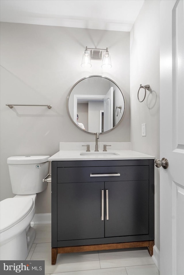 bathroom featuring tile patterned flooring, vanity, and toilet