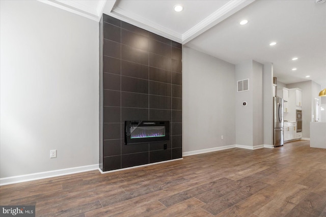 unfurnished living room with heating unit, beam ceiling, dark hardwood / wood-style flooring, and a tiled fireplace