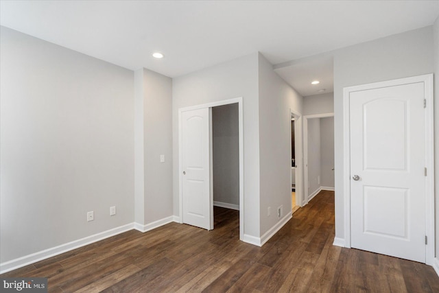 unfurnished bedroom with dark wood-type flooring and a closet