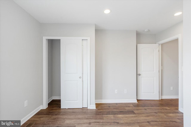 unfurnished bedroom featuring a closet and dark hardwood / wood-style floors