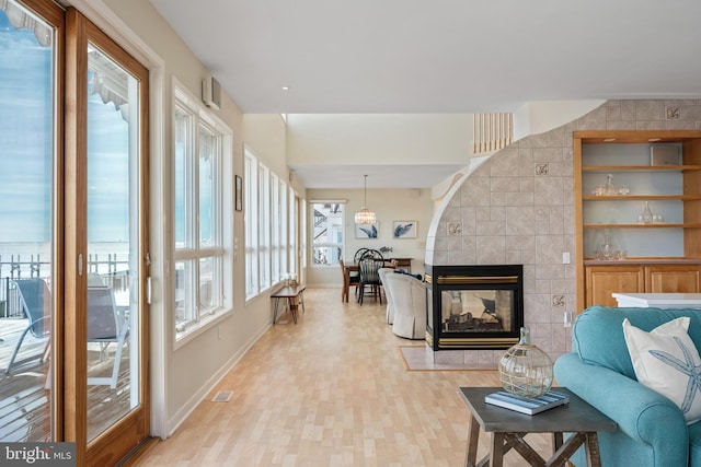 living room featuring light hardwood / wood-style flooring and a tile fireplace