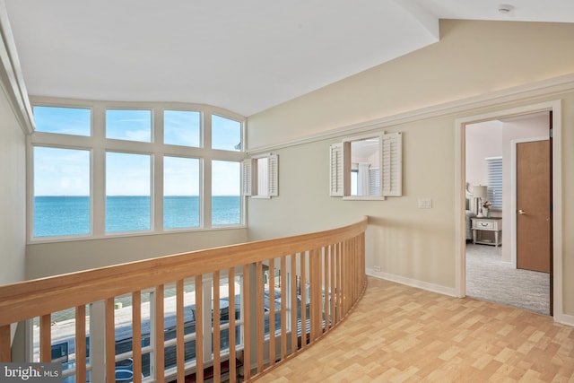 hallway featuring a water view and vaulted ceiling