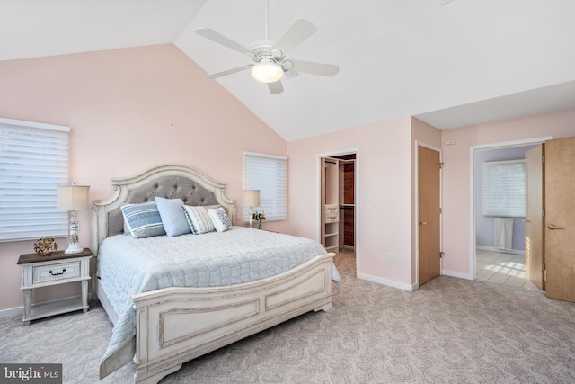 carpeted bedroom featuring a spacious closet, ensuite bath, a closet, vaulted ceiling, and ceiling fan