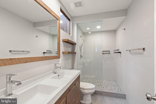 bathroom featuring tiled shower, vanity, and toilet