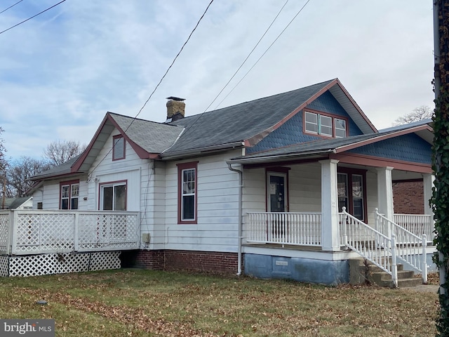 view of front of home with covered porch and a front yard