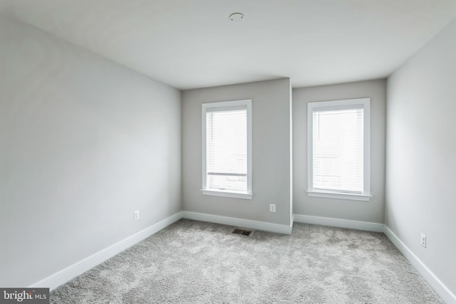 spare room featuring light carpet