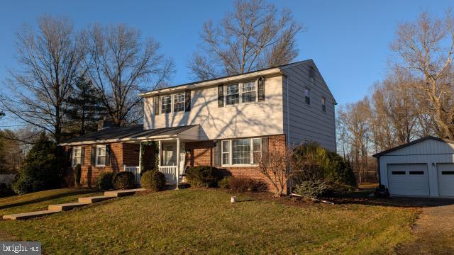 view of front of property with an outbuilding, a garage, a front lawn, and covered porch