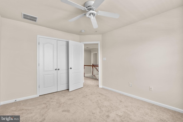 unfurnished bedroom with ceiling fan, a closet, and light carpet