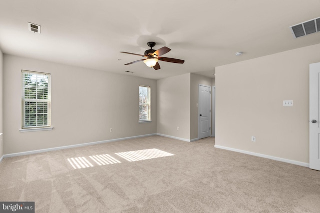 empty room with ceiling fan and light carpet