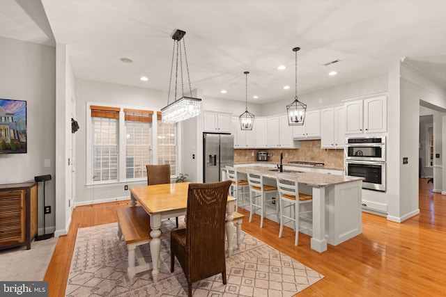 dining space featuring light hardwood / wood-style floors and sink