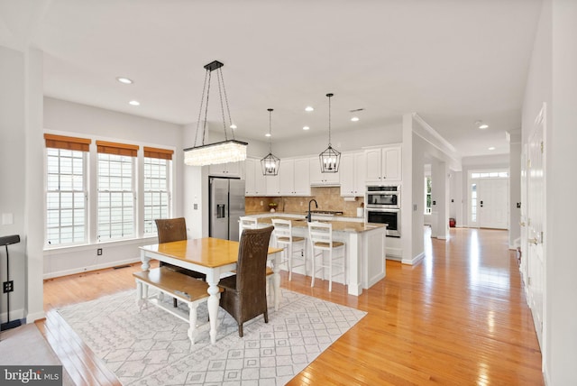 dining area with sink and light wood-type flooring