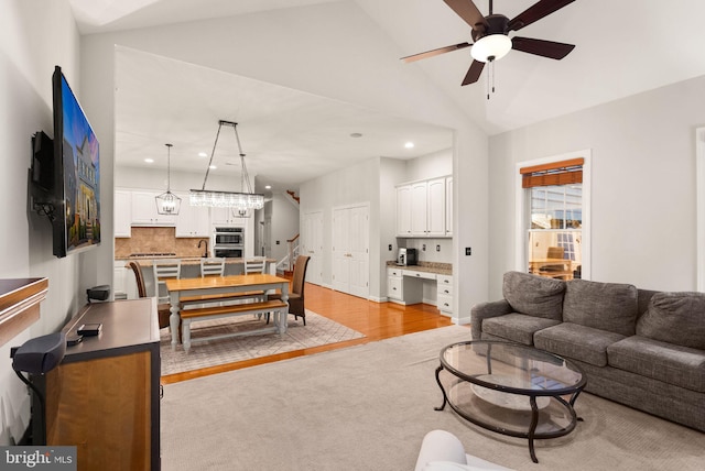 living room featuring ceiling fan, light hardwood / wood-style floors, and high vaulted ceiling