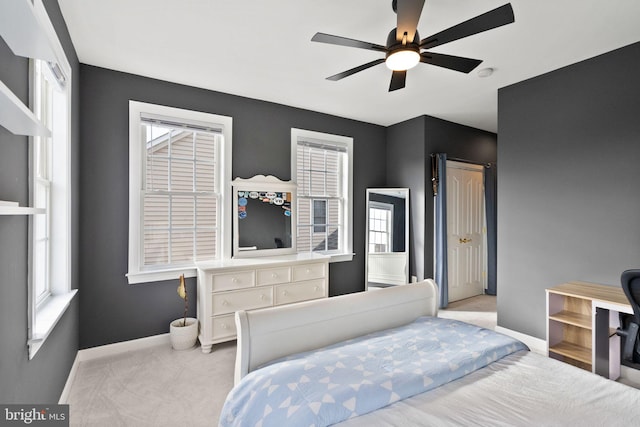 bedroom featuring multiple windows, ceiling fan, and light colored carpet