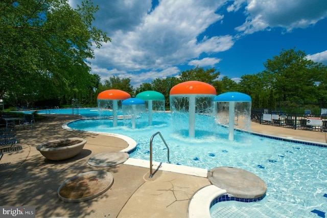 view of swimming pool with pool water feature and a patio