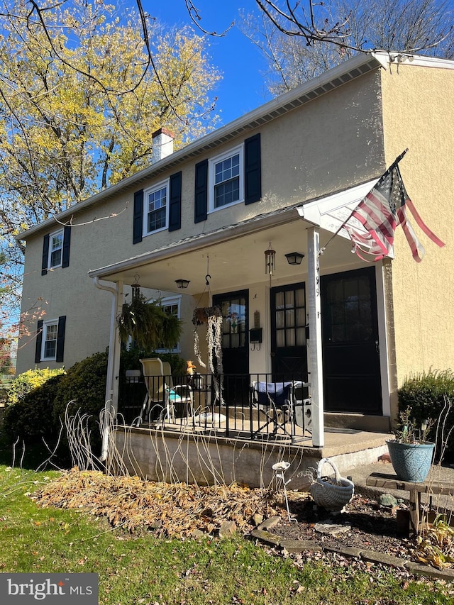 rear view of property featuring covered porch