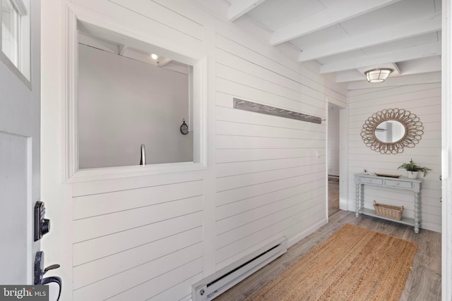 bathroom featuring wooden walls, beamed ceiling, a baseboard radiator, and hardwood / wood-style flooring