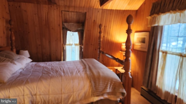 bedroom with a baseboard heating unit and wood walls