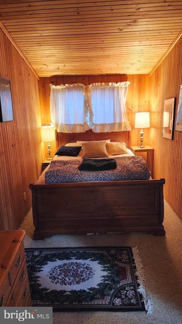 bedroom with carpet, wood walls, and wooden ceiling